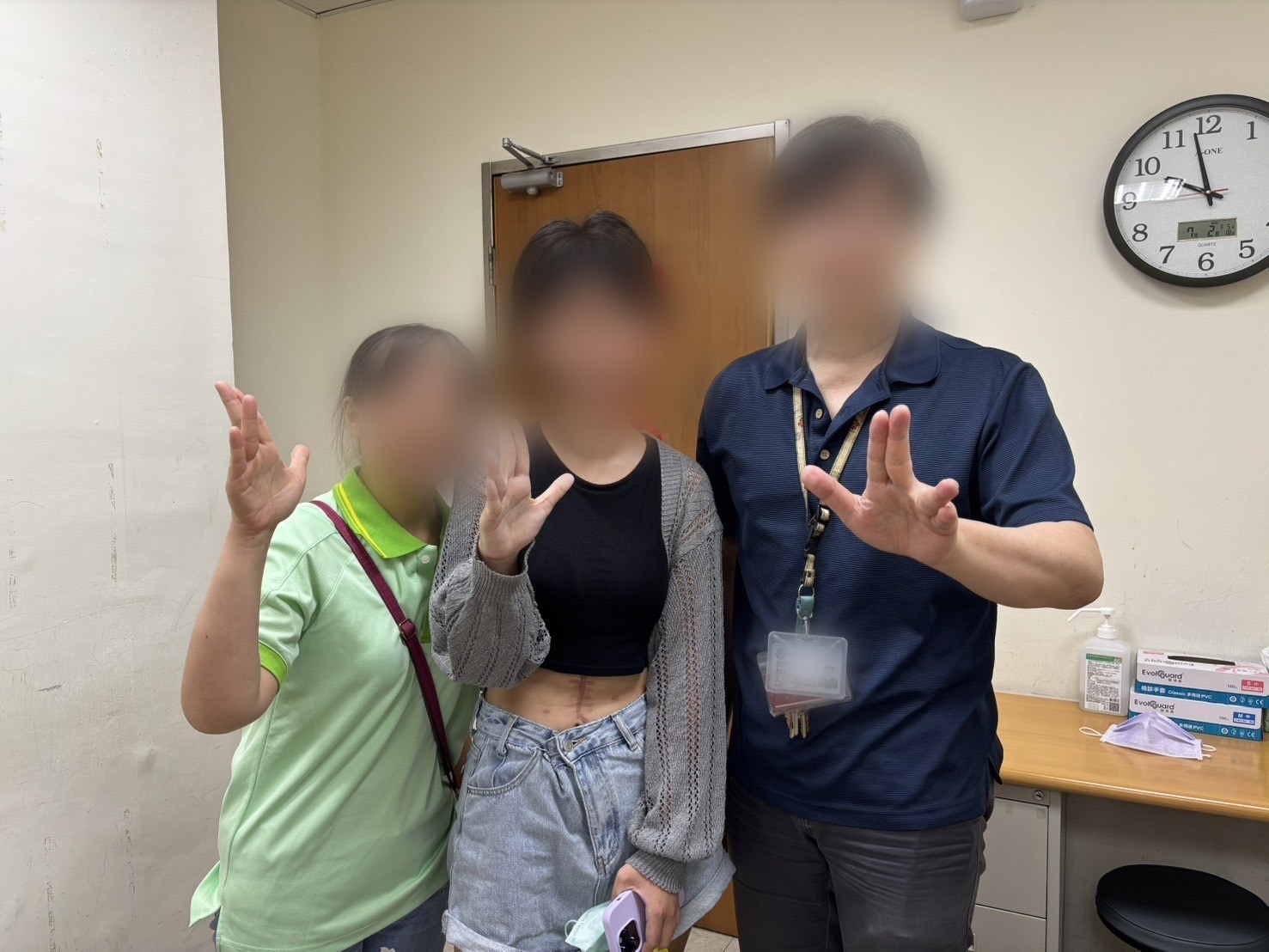 腹部正中線的癒合疤痕;鏡頭拉遠後可見三人並肩、同時舉起手——面部已去識別化。
